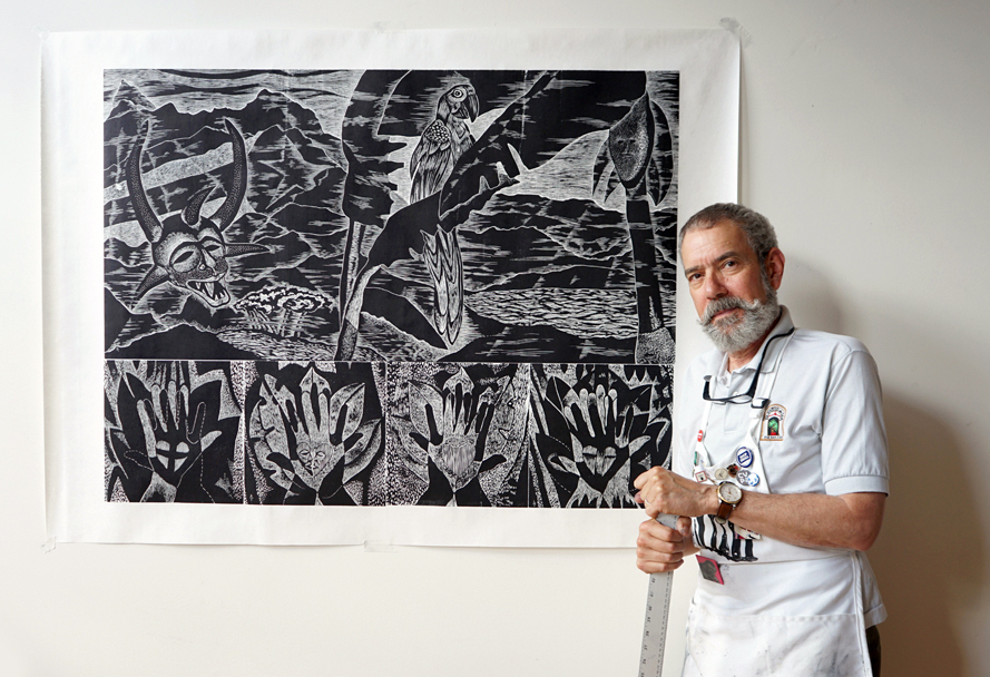 Adrian Tio standing next to his Big Ink print Mama Aida's Isla Verde